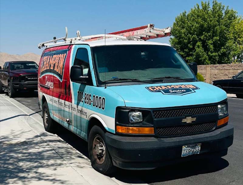 Light blue service van with Champion branding and logo on the side, parked outside.